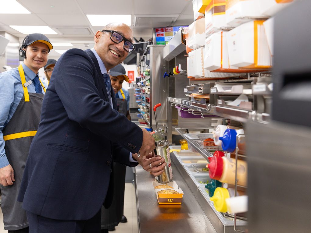 McDonald’s franchisee helping prepare burgers in the kitchen at the Rickmansworth restaurant opening, photographed for PR and press use.