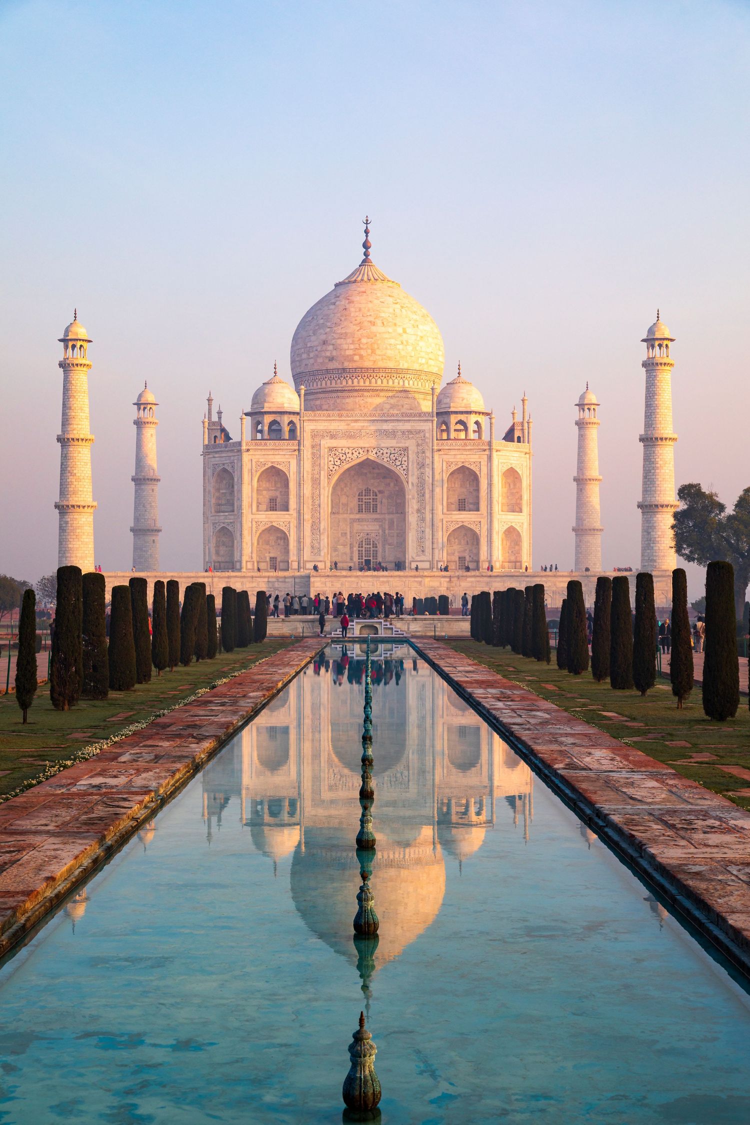 The Taj Mahal reflected in the reflecting pool at sunrise in Agra, India, photographed for travel and tourism marketing.