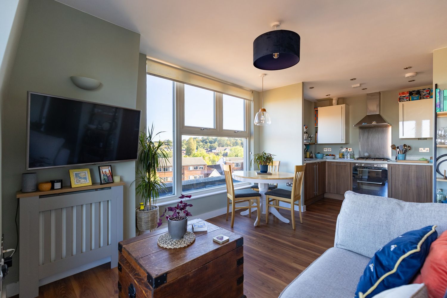 Interior panoramic view of a modern open concept living room with hardwood floors and natural lighting.