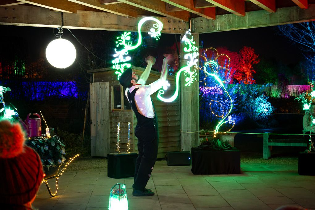 Colourful neon light art installations illuminating a dark outdoor space during the nighttime Glow event at RHS Bridgewater.