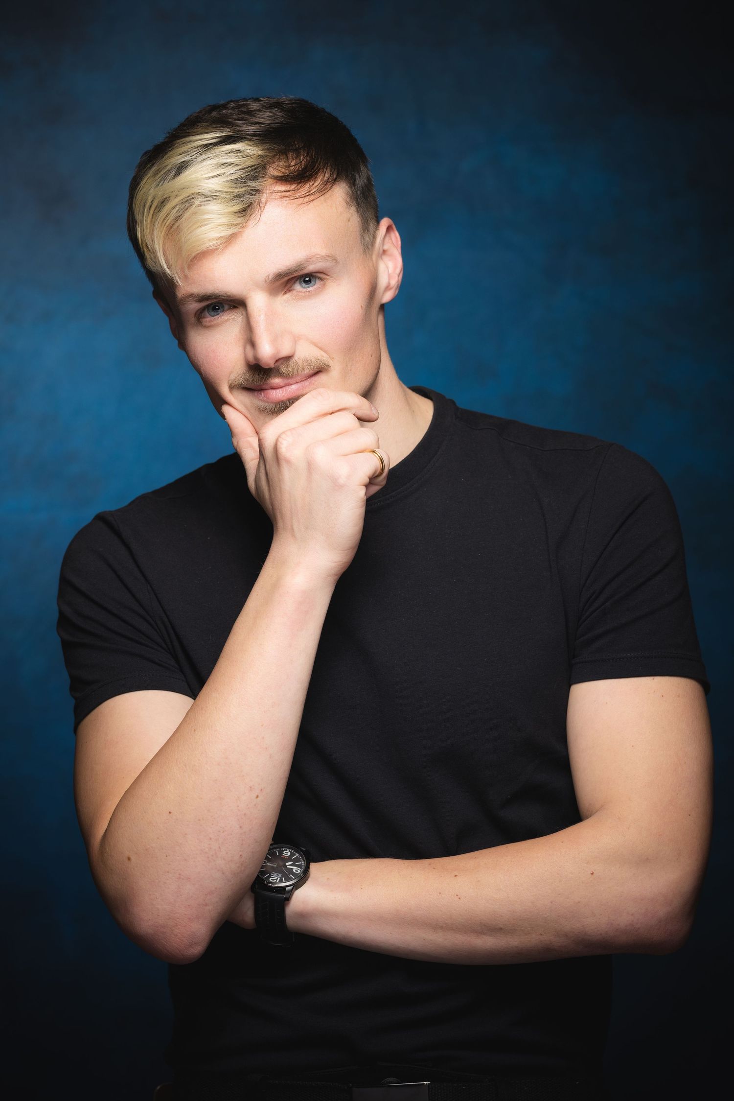 Actor headshot portrait series with expressive gestures photographed against blue backdrop at Castle Theatre Wellingborough