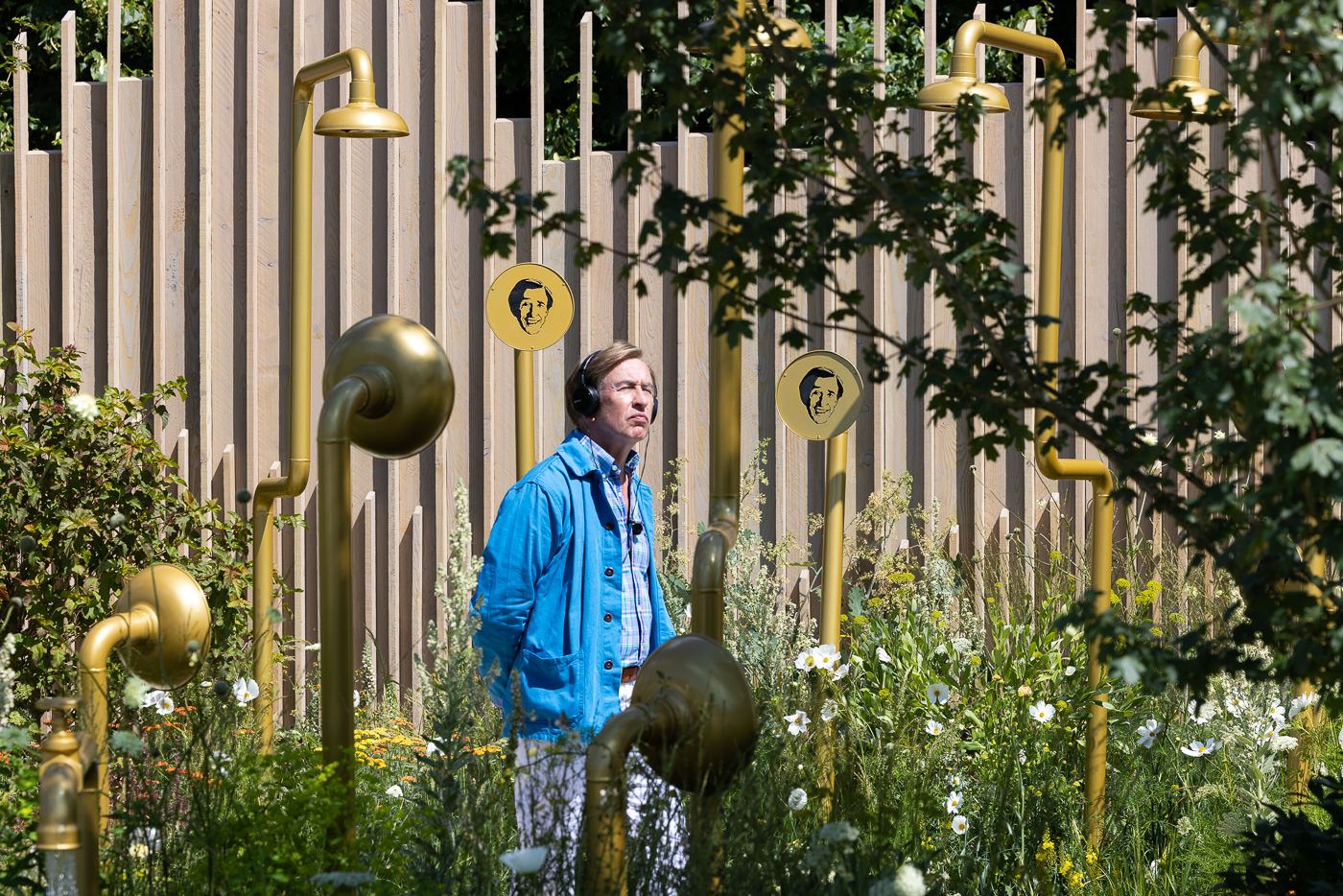 Steve Coogan in character, filming for Audible among garden plants