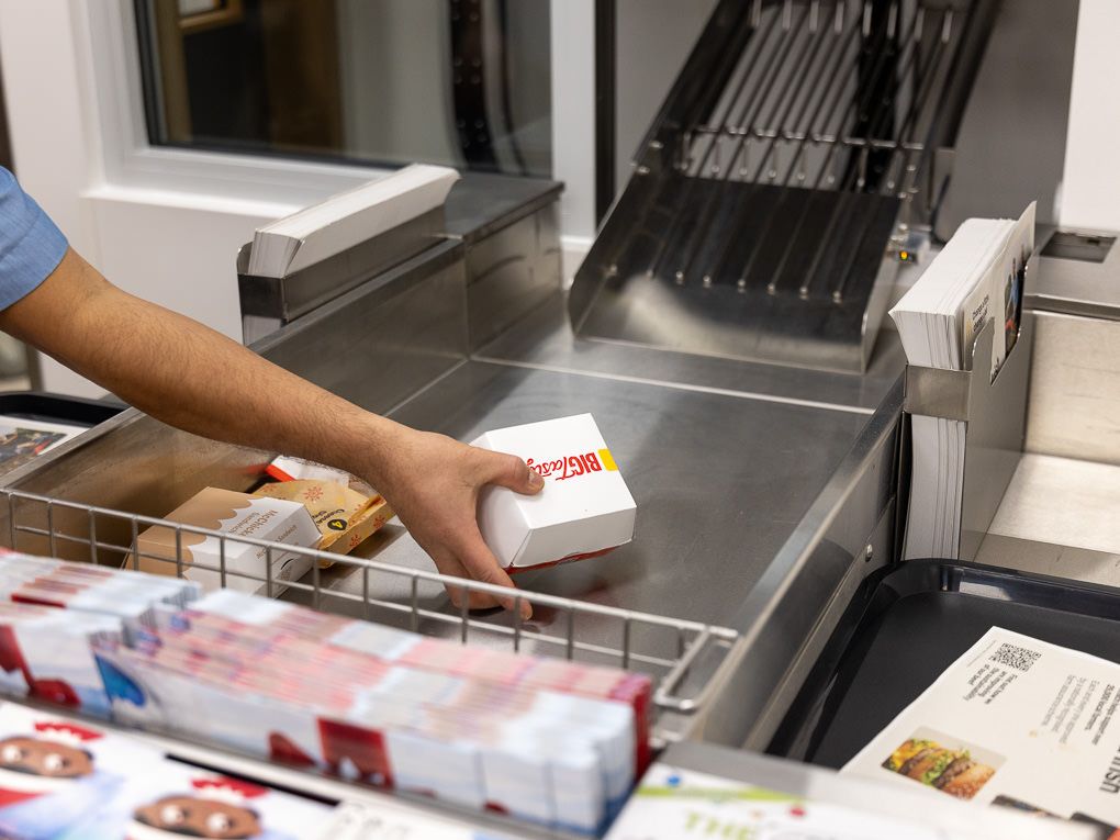 McDonald’s kitchen staff preparing food at a stainless steel counter during the Rickmansworth restaurant opening, photographed for PR use.