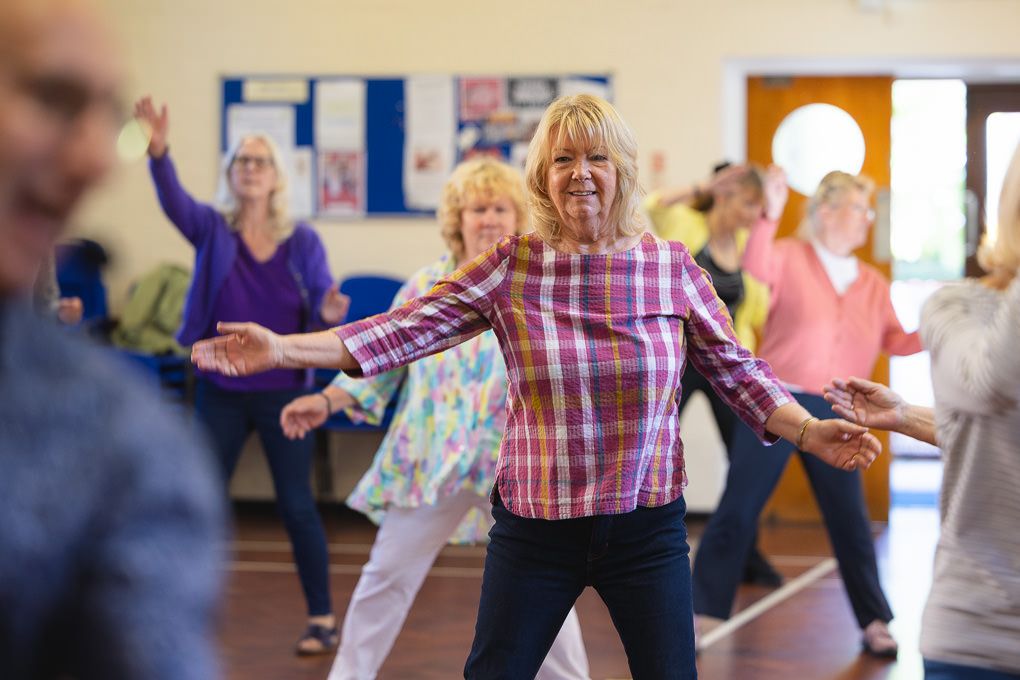 Senior adults participate in a group dance exercise class at a Letchworth community centre.
