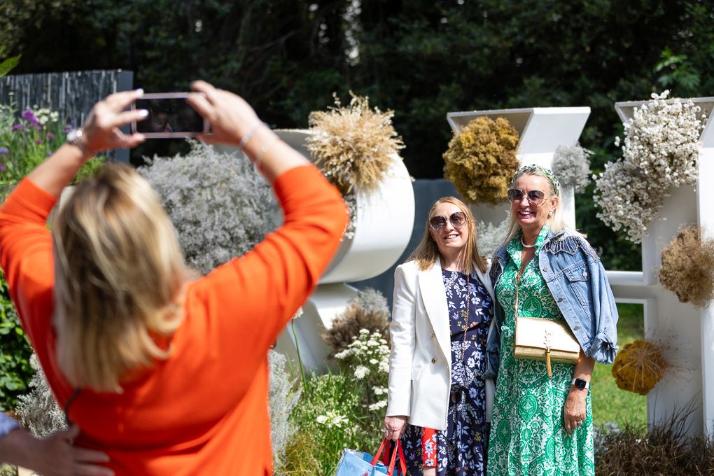 Students gathered outdoors learning how to collect and preserve flowers at the RHS Chelsea Flower Show in London