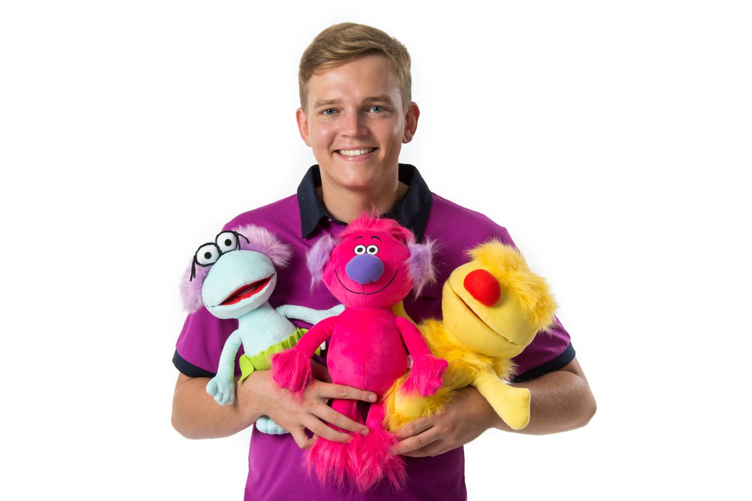 Caregiver in purple shirt holds colorful Sesame Street puppet characters including Elmo and Big Bird plush toys.