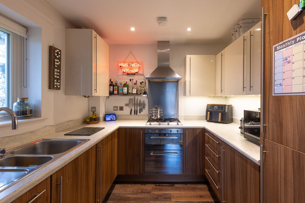 Real estate photography of a modern galley-style kitchen in a luxury apartment in Hertfordshire.