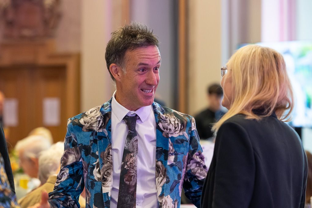 Guests at a formal event share laughter and conversation at the RHS Britain in Bloom awards 2025 in Brighton.