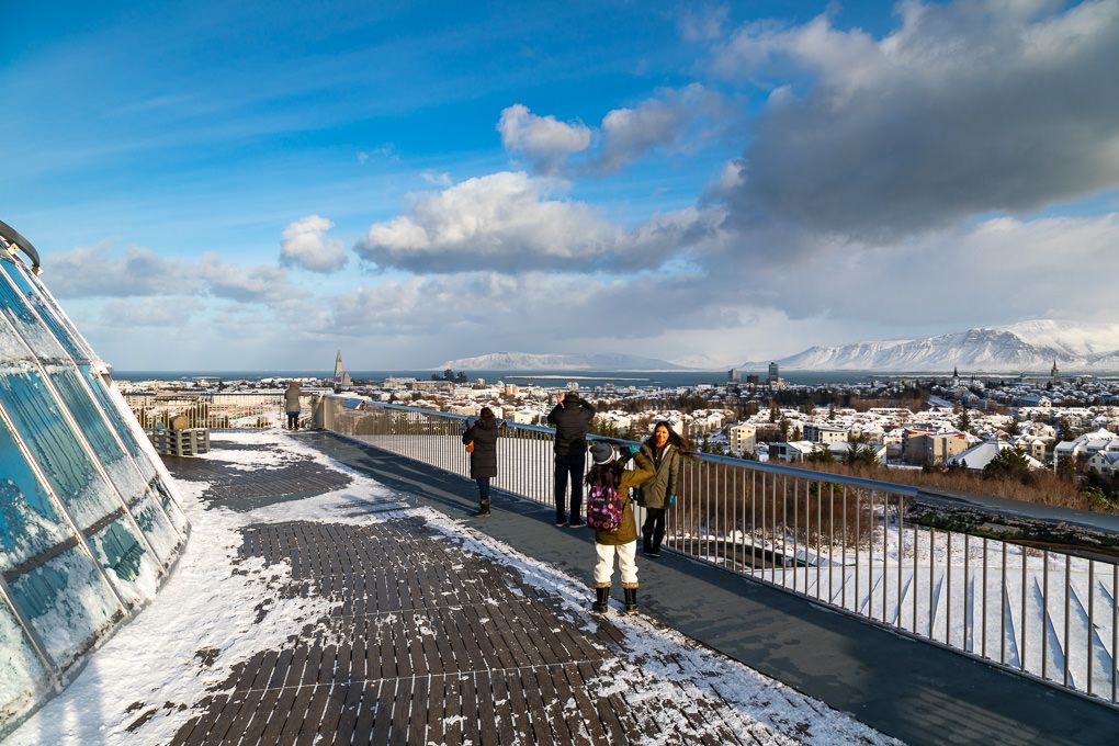 A panoramic view of Reykjavik, Iceland, under blue skies with white puffy clouds.
