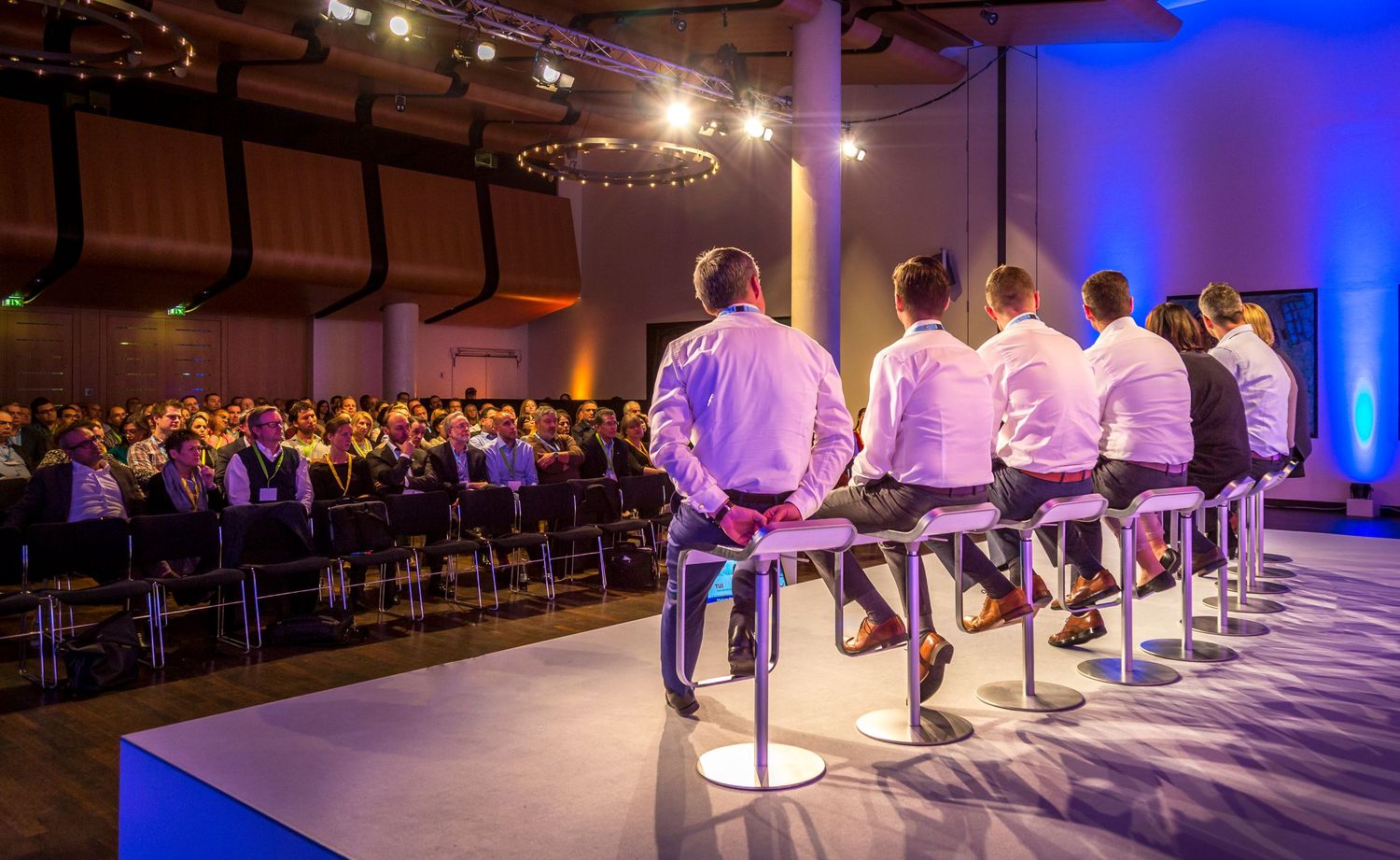 Panel discussion taking place on stage during a business conference with delegates in attendance