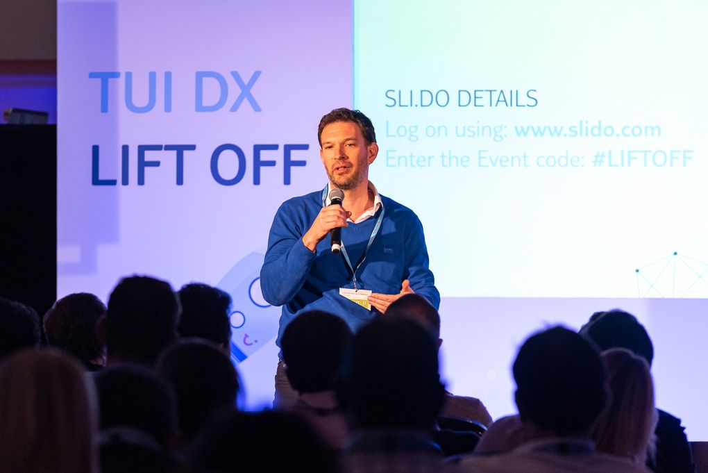 Speaker presenting on stage at a TUI conference event at the Brewery in London.