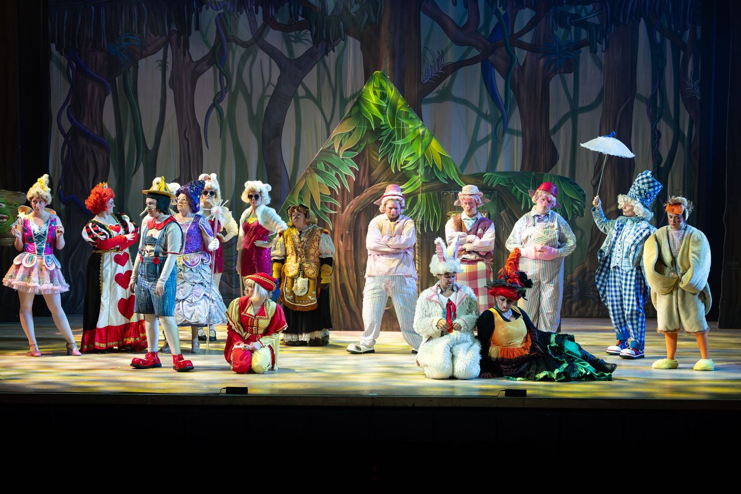 Wide view of a whimsical forest set with colourful costumed cast during Shrek The Musical at Castle Theatre Wellingborough