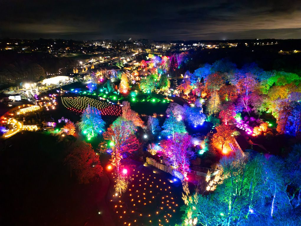 Aerial light trail photography of RHS Harlow Carr during their winter Glow event. The garden is illuminated by hundreds of colourful LEDs.