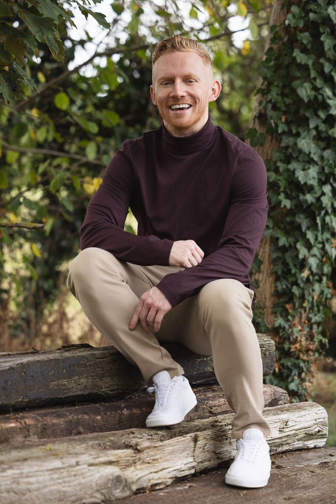 Casual autumn fashion shot showing a burgundy turtleneck sweater paired with khaki pants and white sneakers.