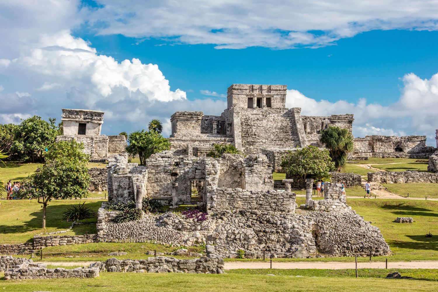 Ancient Mayan ruins of Tulum under blue sky with white clouds in Mexico.