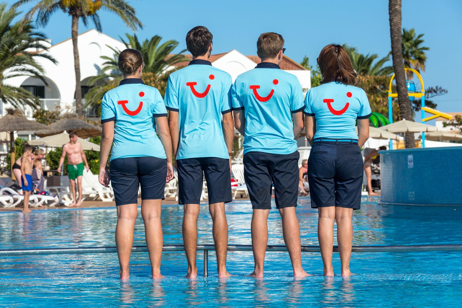 Four TUI Reps in TUI uniform show off the TUI smile logo.
