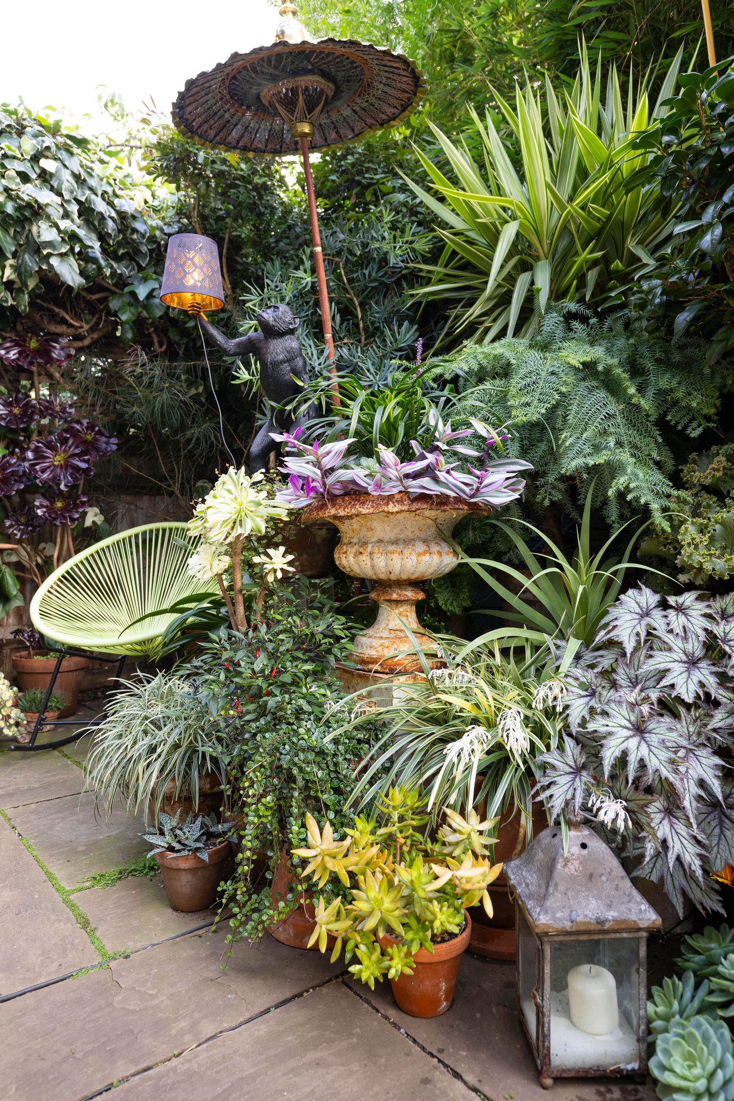 Garden patio with landscaped planting, outdoor seating and decorative features showcasing residential exterior design.