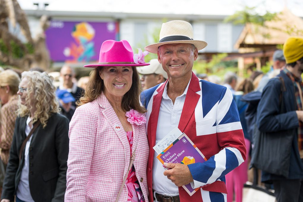 People in pink and white enjoying a festive outdoor moment at the RHS Chelsea Flower Show in London, captured for press photography