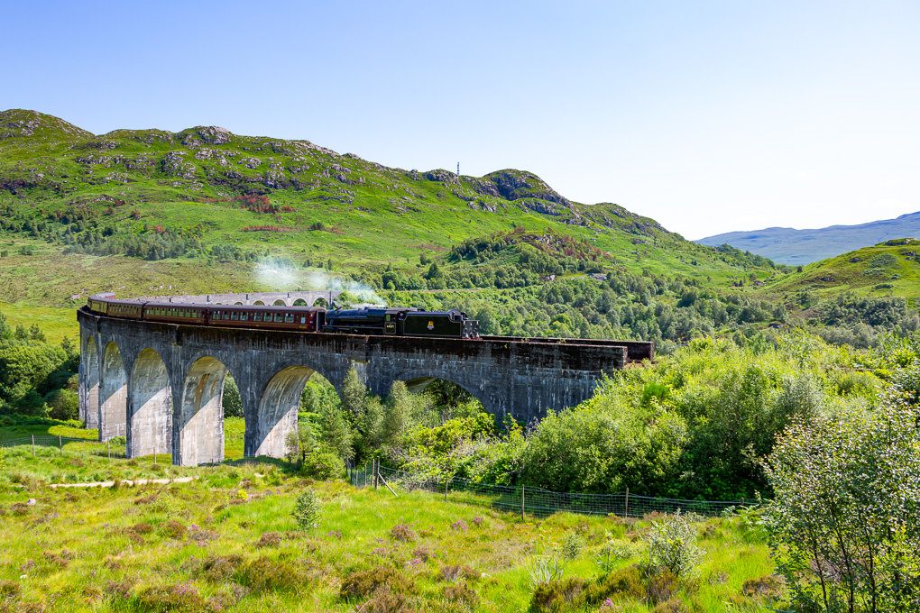 The Jacobite Express steam train travelling over the Glenfinnan Viaduct in Scotland.