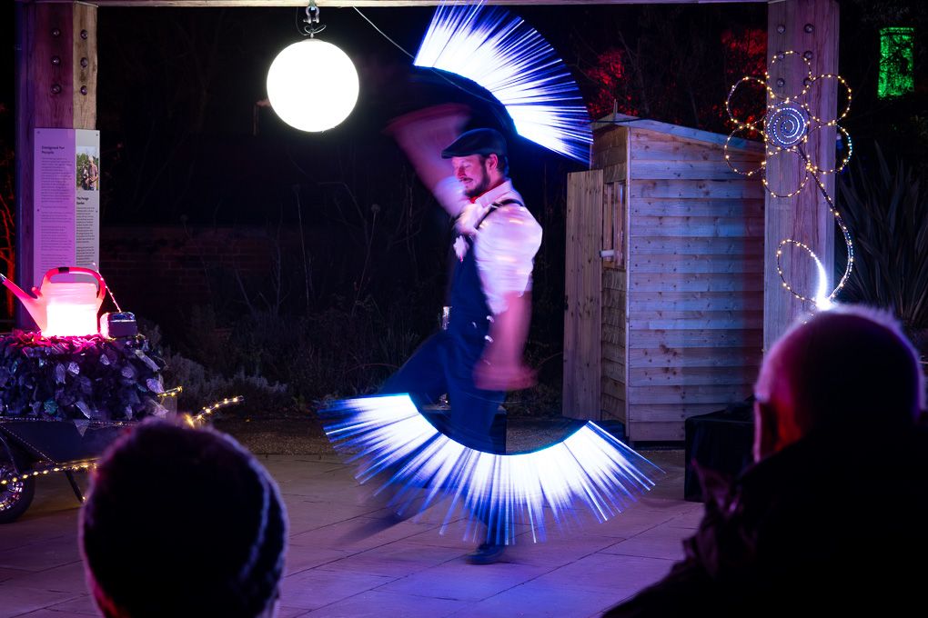 Long-exposure blue light spiral created during the illuminated performance at Glow at RHS Bridgewater, captured in the nighttime trail.