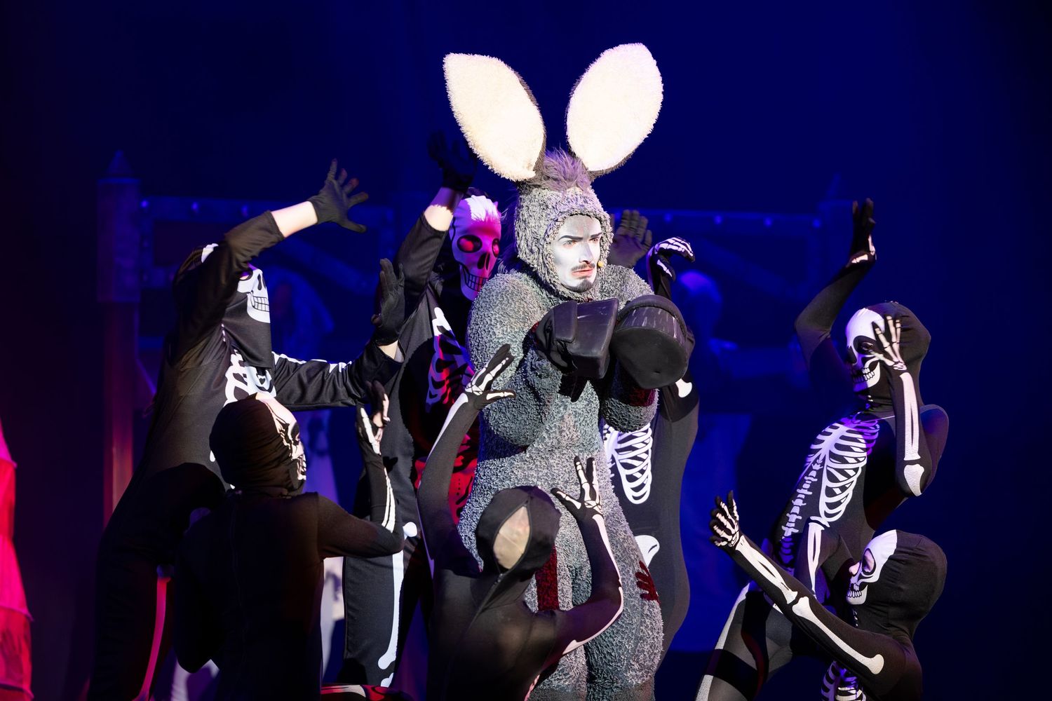 Skeleton and Donkey characters dance under blue stage lighting during Shrek The Musical at Castle Theatre Wellingborough