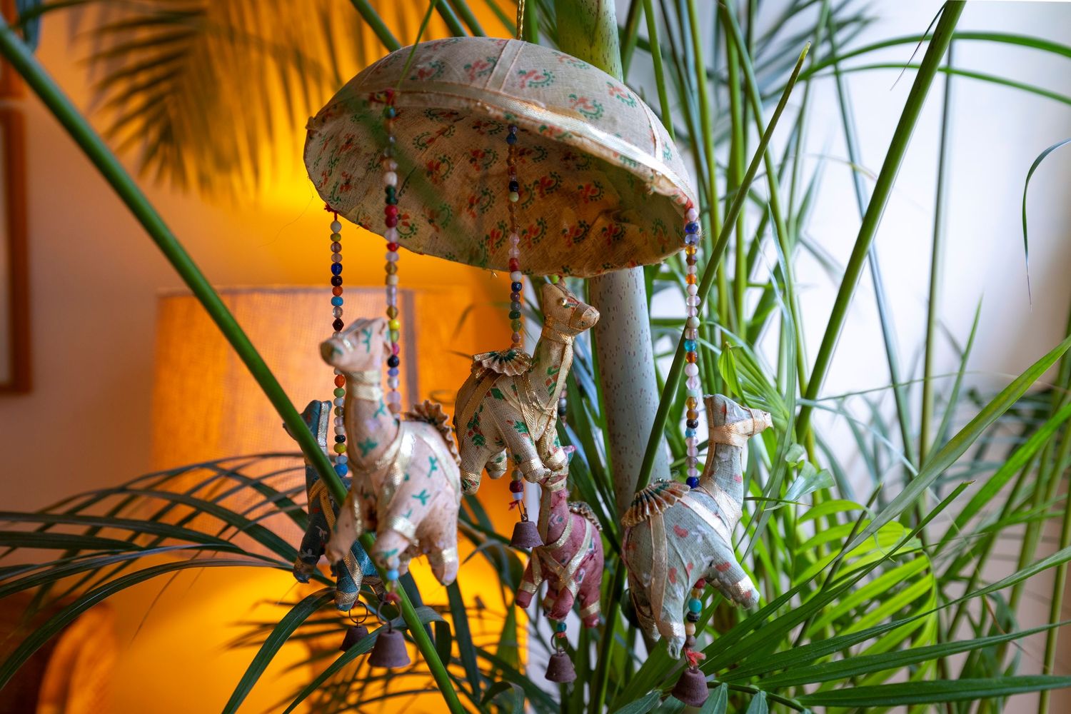 Interior design detail featuring decorative wind chime and tropical plants in a stylish residential living space.