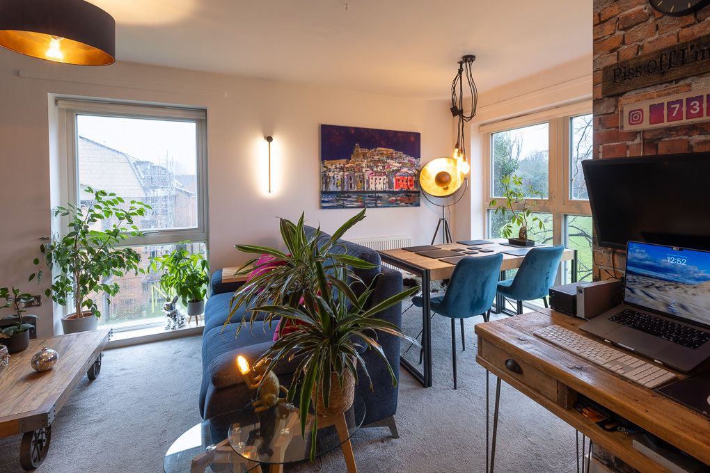 Property photography of a modern apartment interior, featuring a mix of potted plants and contemporary furnishings in natural light.