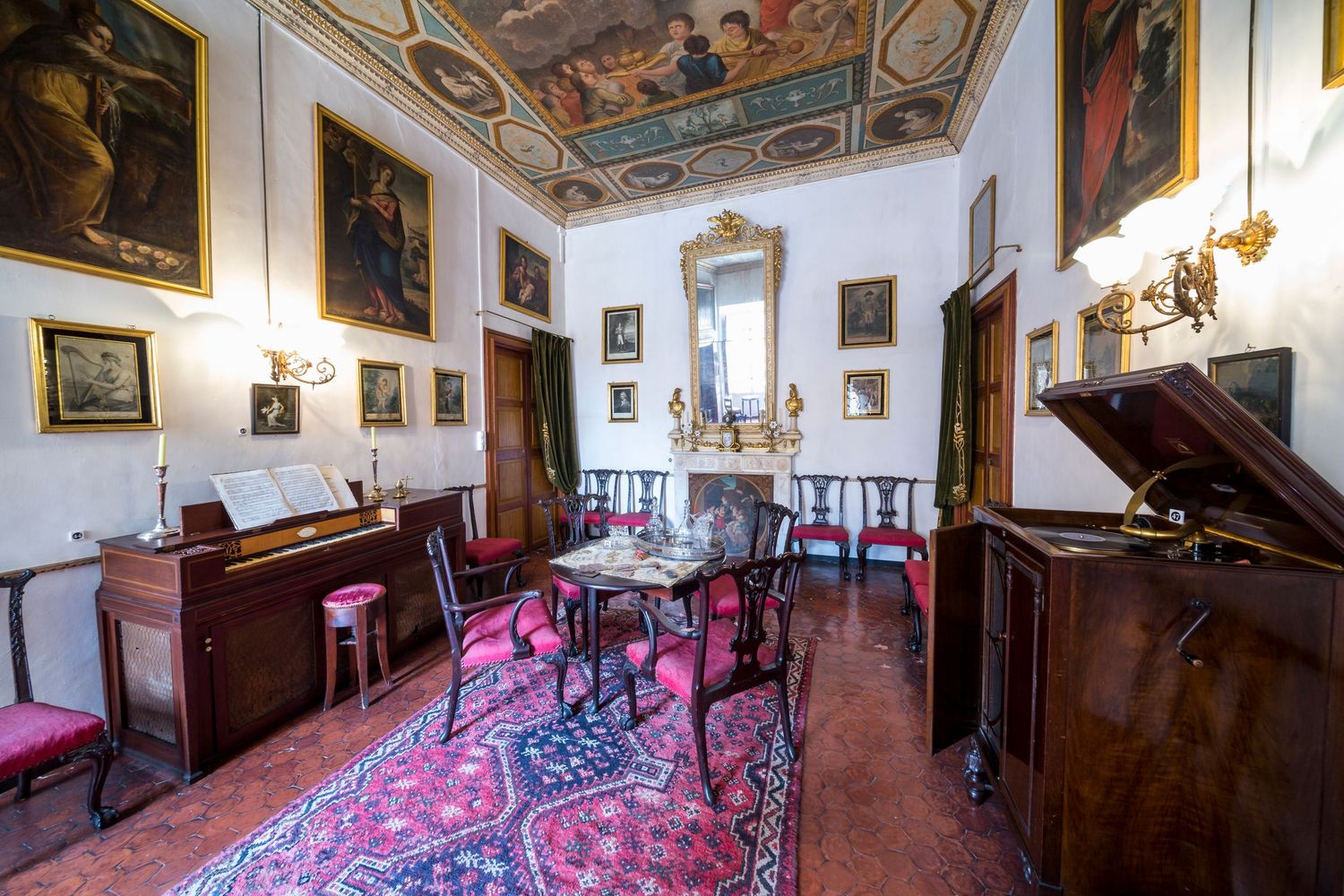 Historic Italian villa interior featuring frescoed ceiling, antique furnishings and classic architectural details.