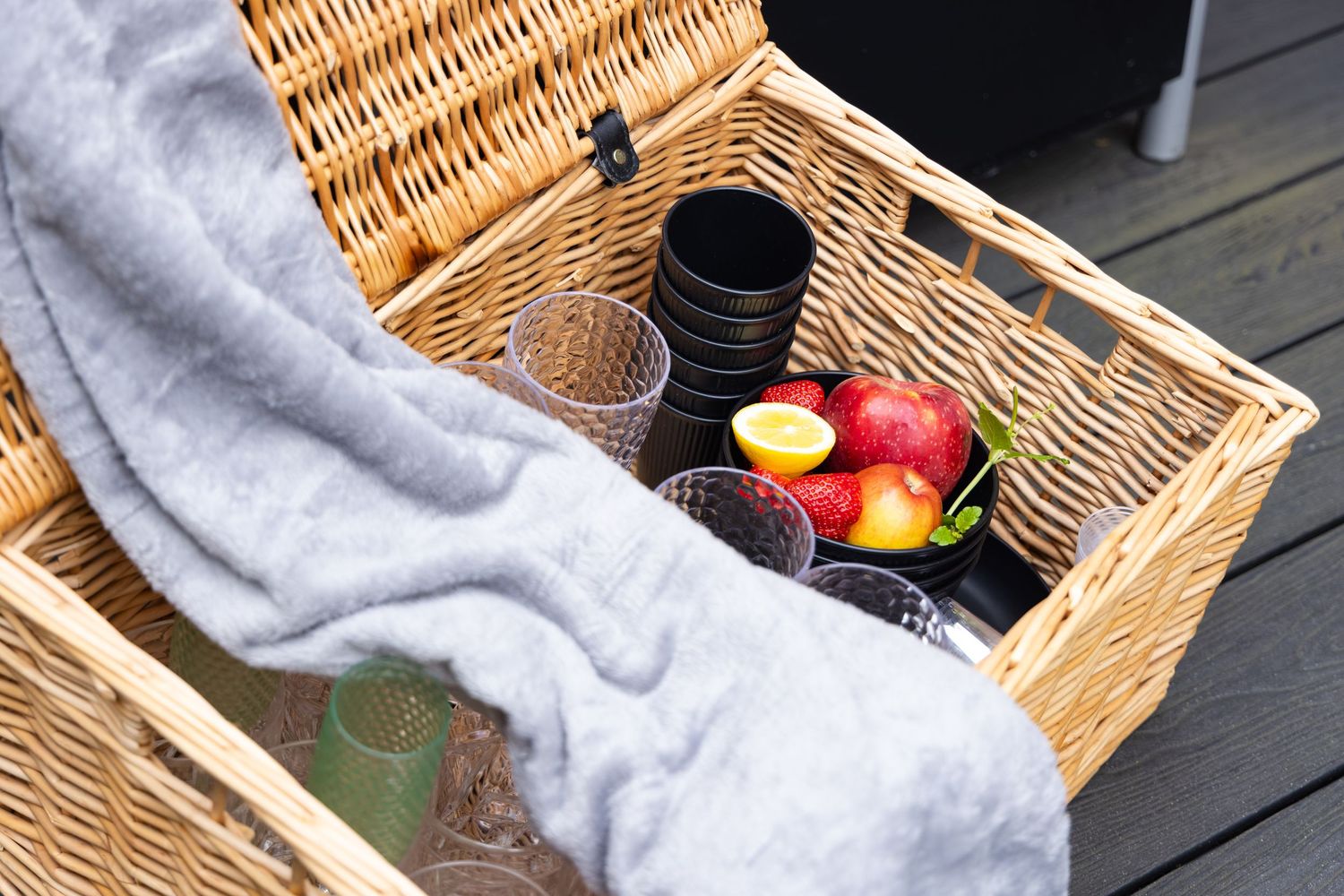 Styled picnic setup on spa deck in Bedfordshire with basket, blanket, wine and apples, photographed during spa shoot.