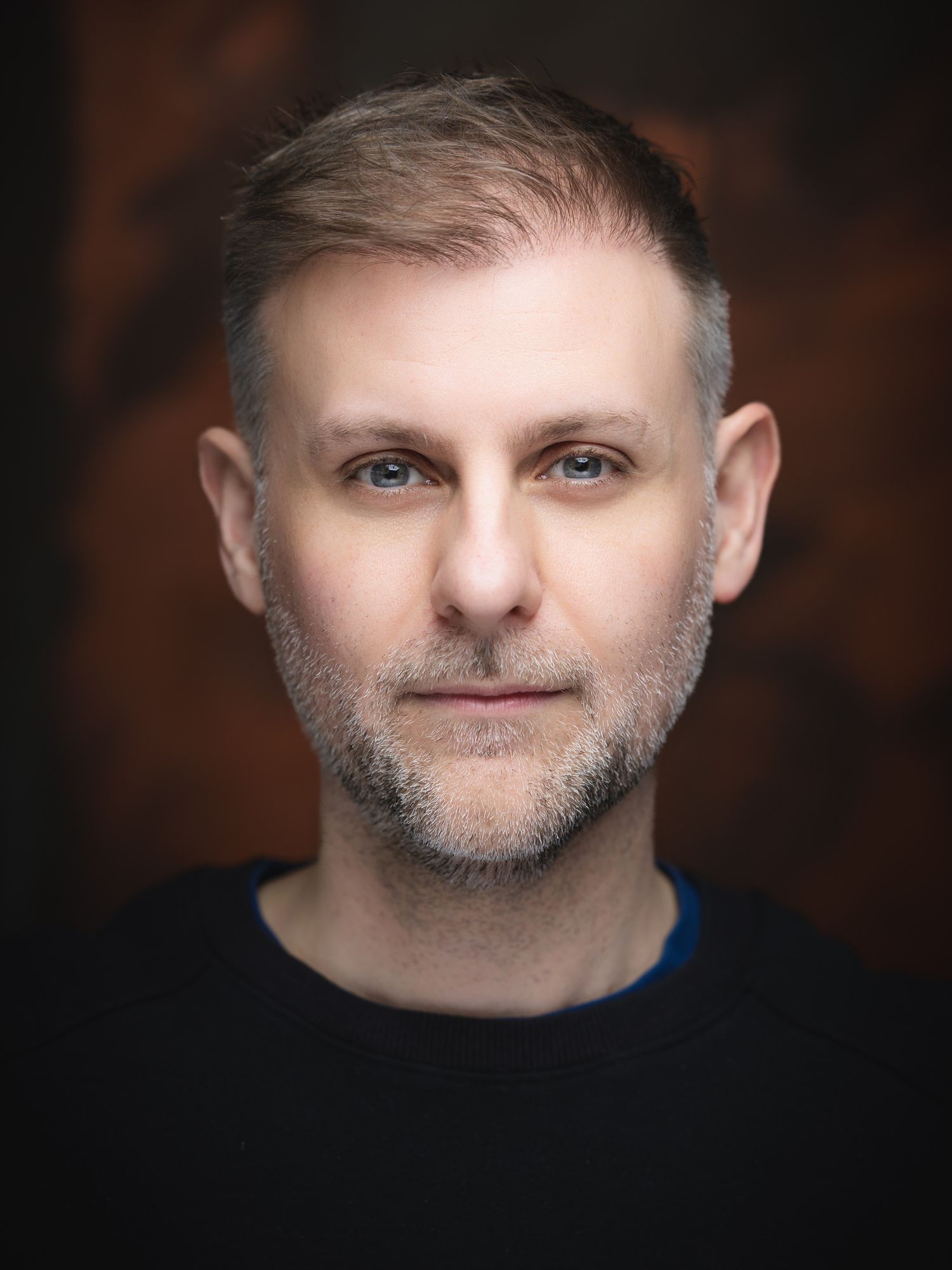 Professional headshot of commercial photographer Lee Charlton against a dark studio background.