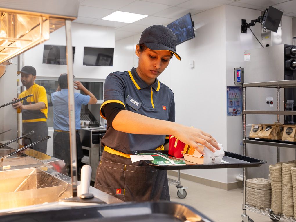 McDonald’s crew member preparing food at the counter during the Rickmansworth restaurant opening, photographed for PR and press use.
