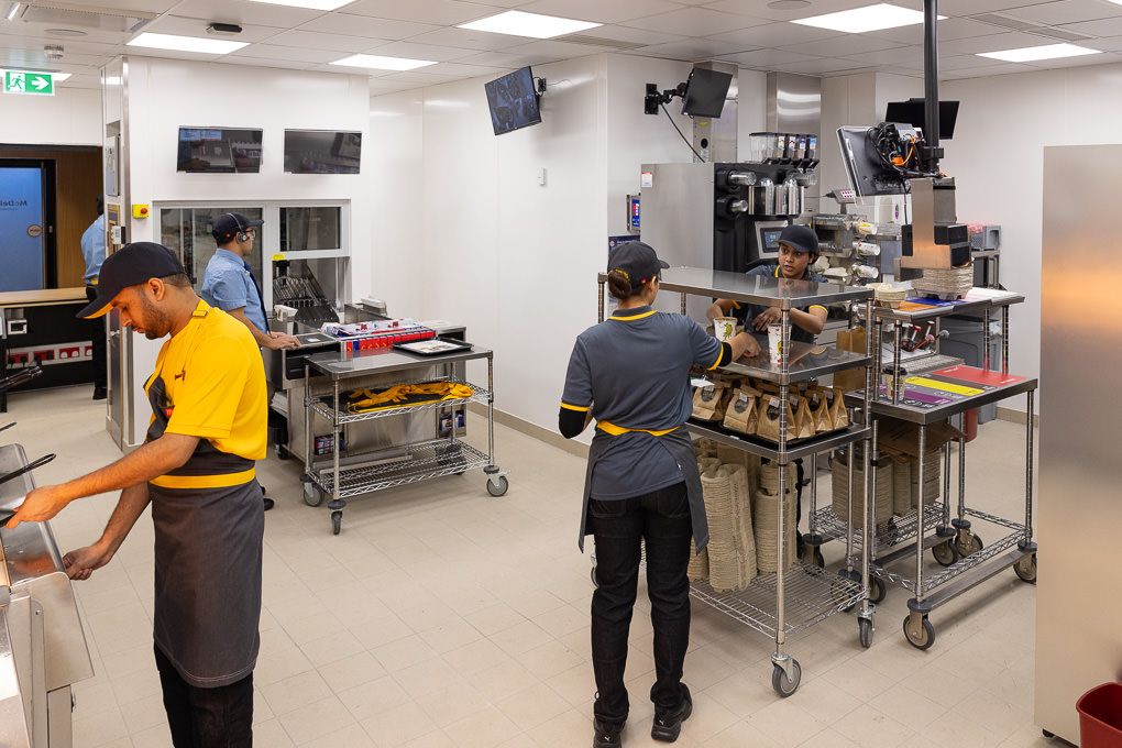McDonald’s kitchen staff working at stainless steel prep stations during the Rickmansworth restaurant opening, photographed for PR and press