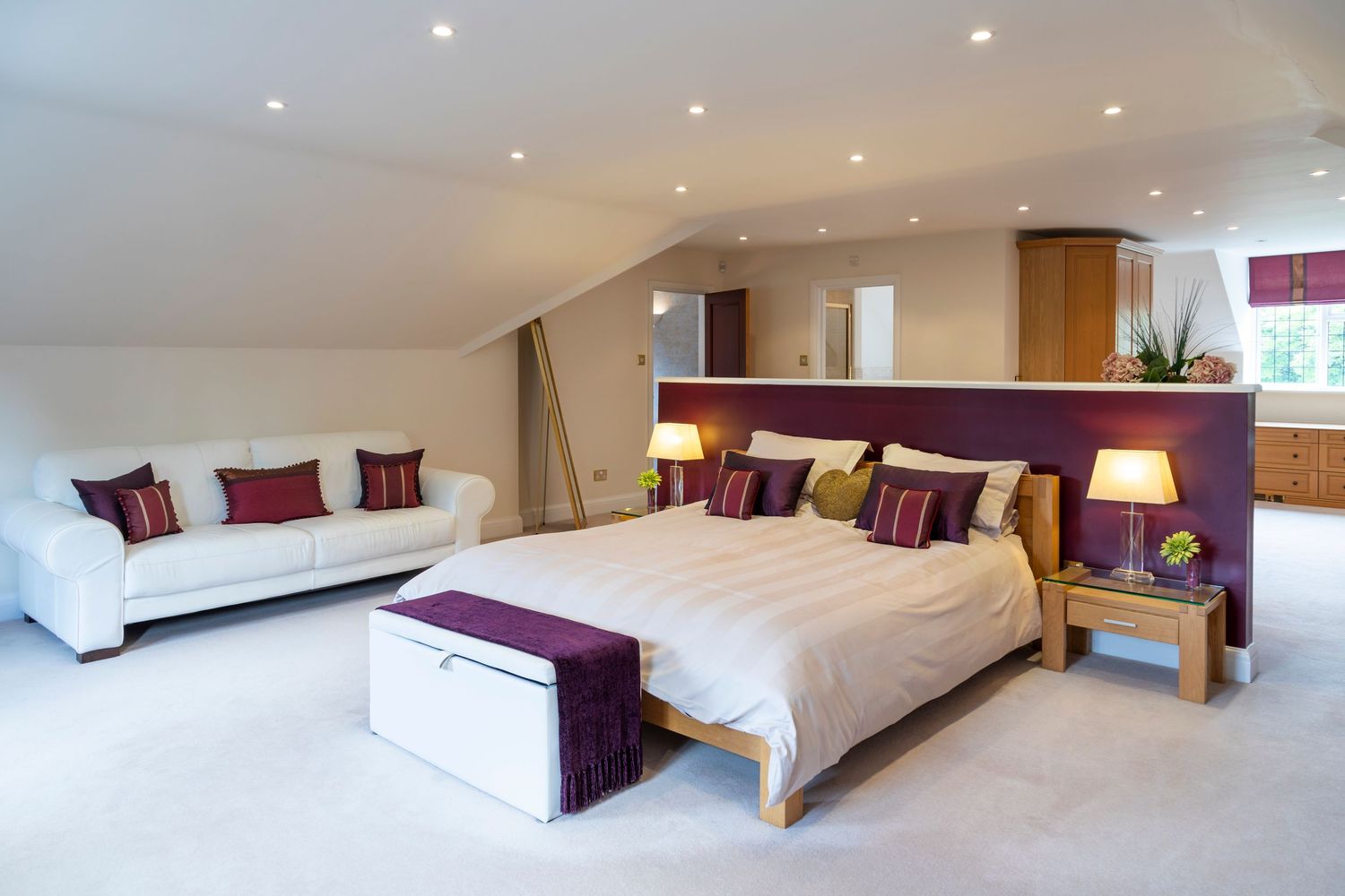 Spacious loft bedroom with king-size bed and modern furnishings, photographed for property and interior marketing.