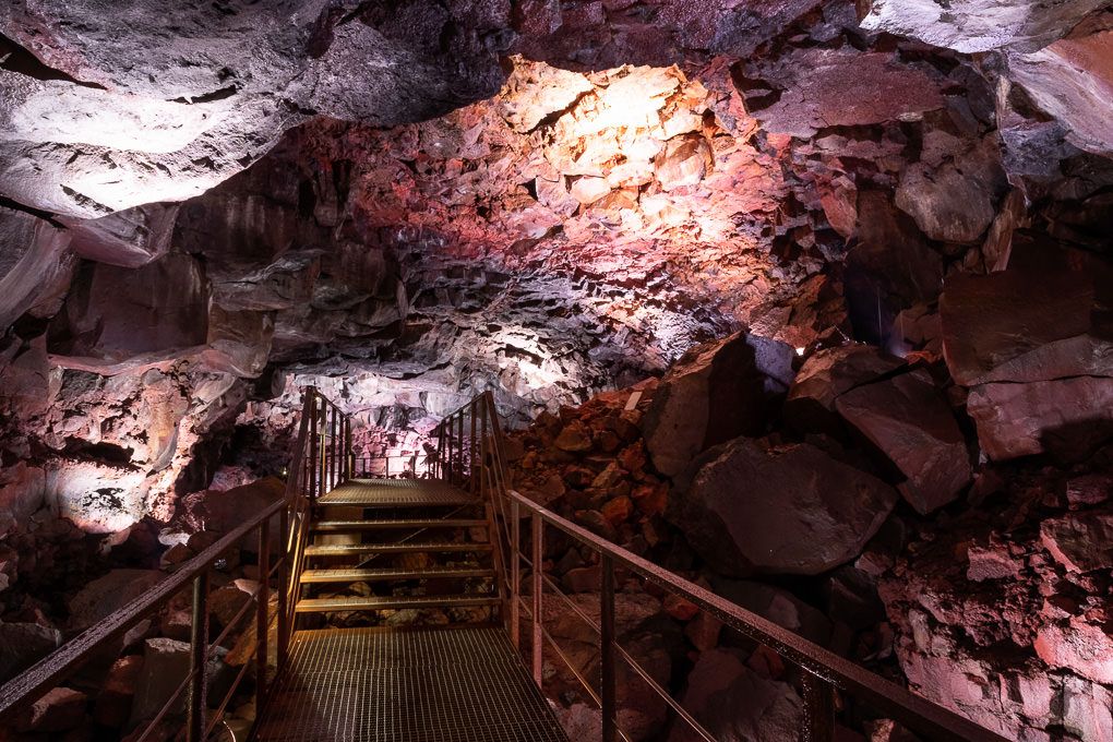 Illuminated wooden walkway through the dramatic lava tunnel system of Raufarhólshellir in Iceland.