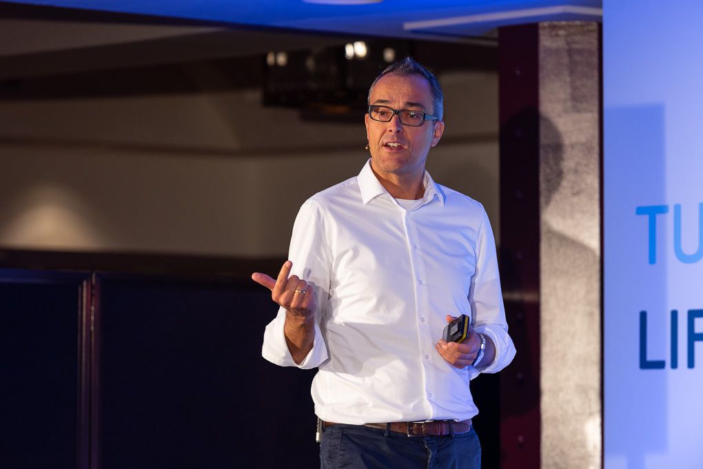 A low-light conference in London. TUI's David Schelp delivers a speech to his leadership team.