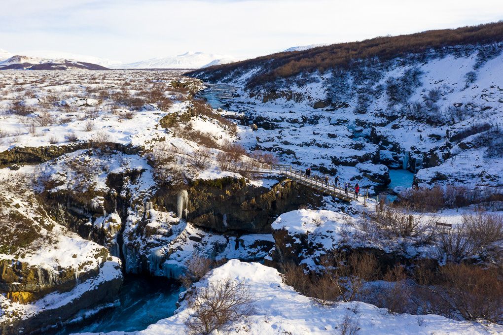 An aerial view of Iceland's Hraunfossar Waterfalls during the winter.