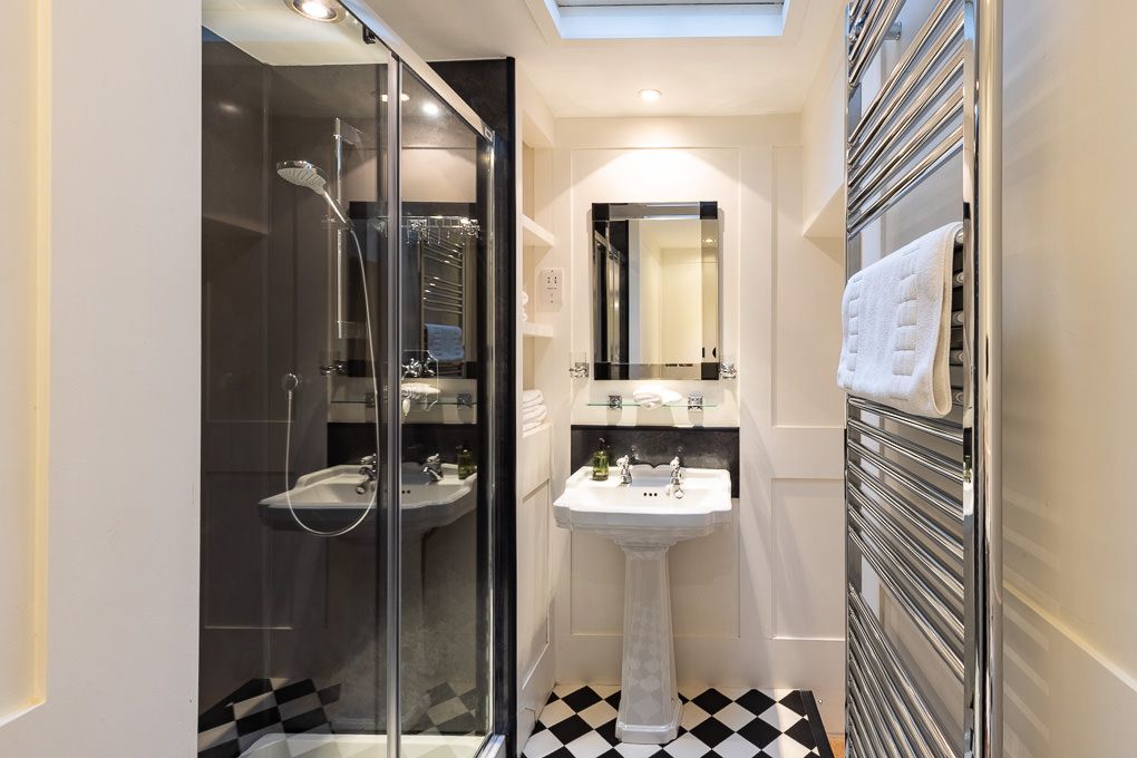 Modern bathroom with checkered tiles and heated towel rail in holiday apartment - interior photography showcasing features