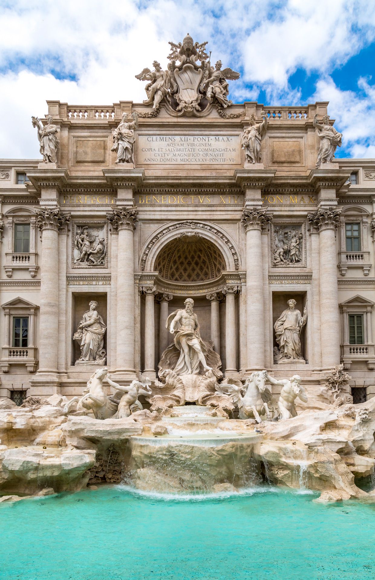 The ornate Baroque architecture and turquoise waters of Rome's famous Trevi Fountain on a sunny day.