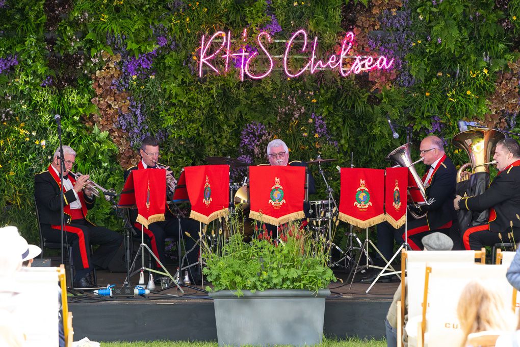 Press photography of a brass band playing on stage at the RHS Chelsea Flower Show in London.