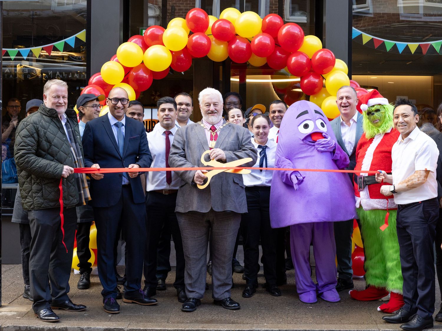 Ribbon cutting ceremony at a McDonald’s restaurant opening attended by staff, guests and mascot characters
