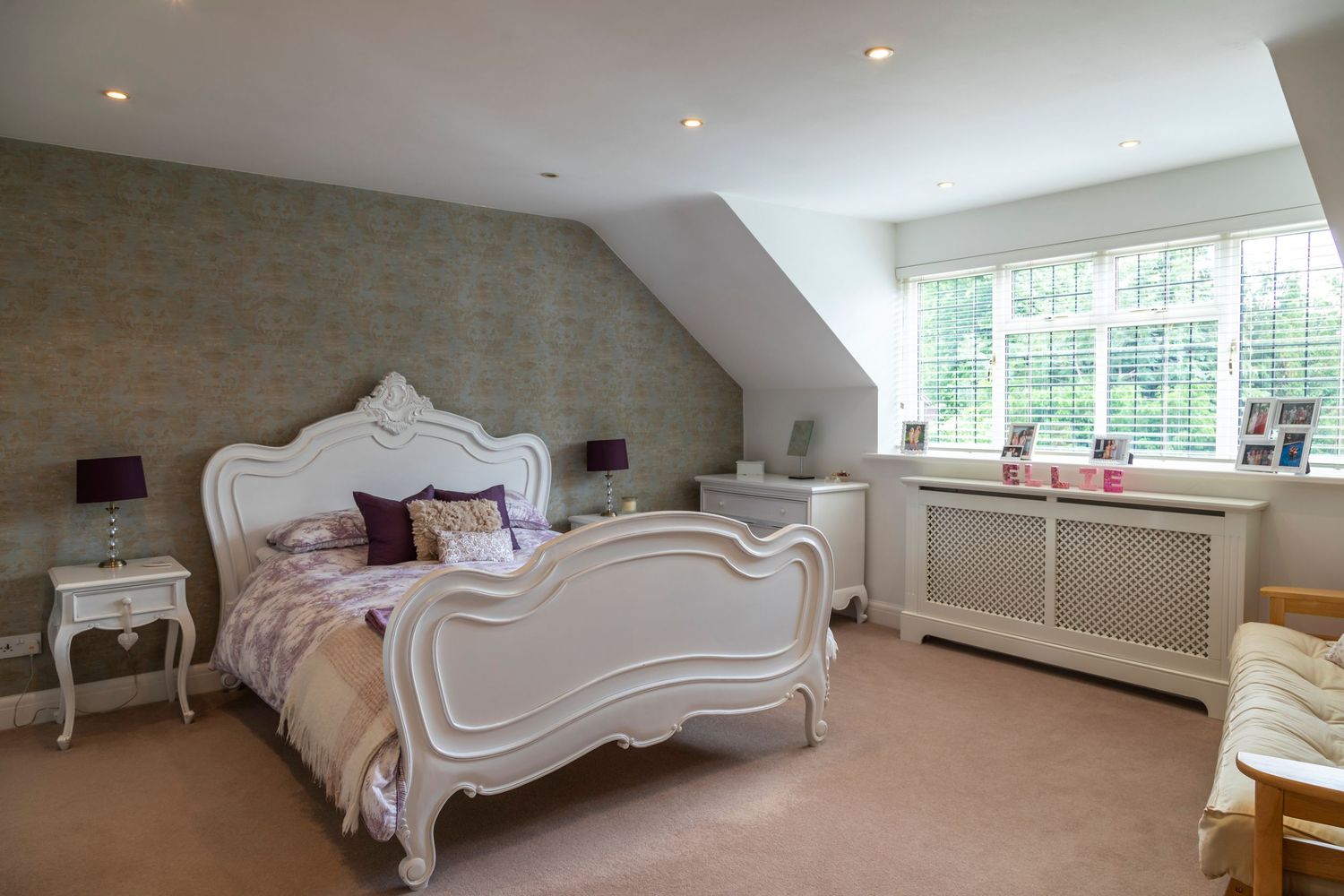 Luxury attic bedroom with French-style furnishings, natural light and elegant interior design details.