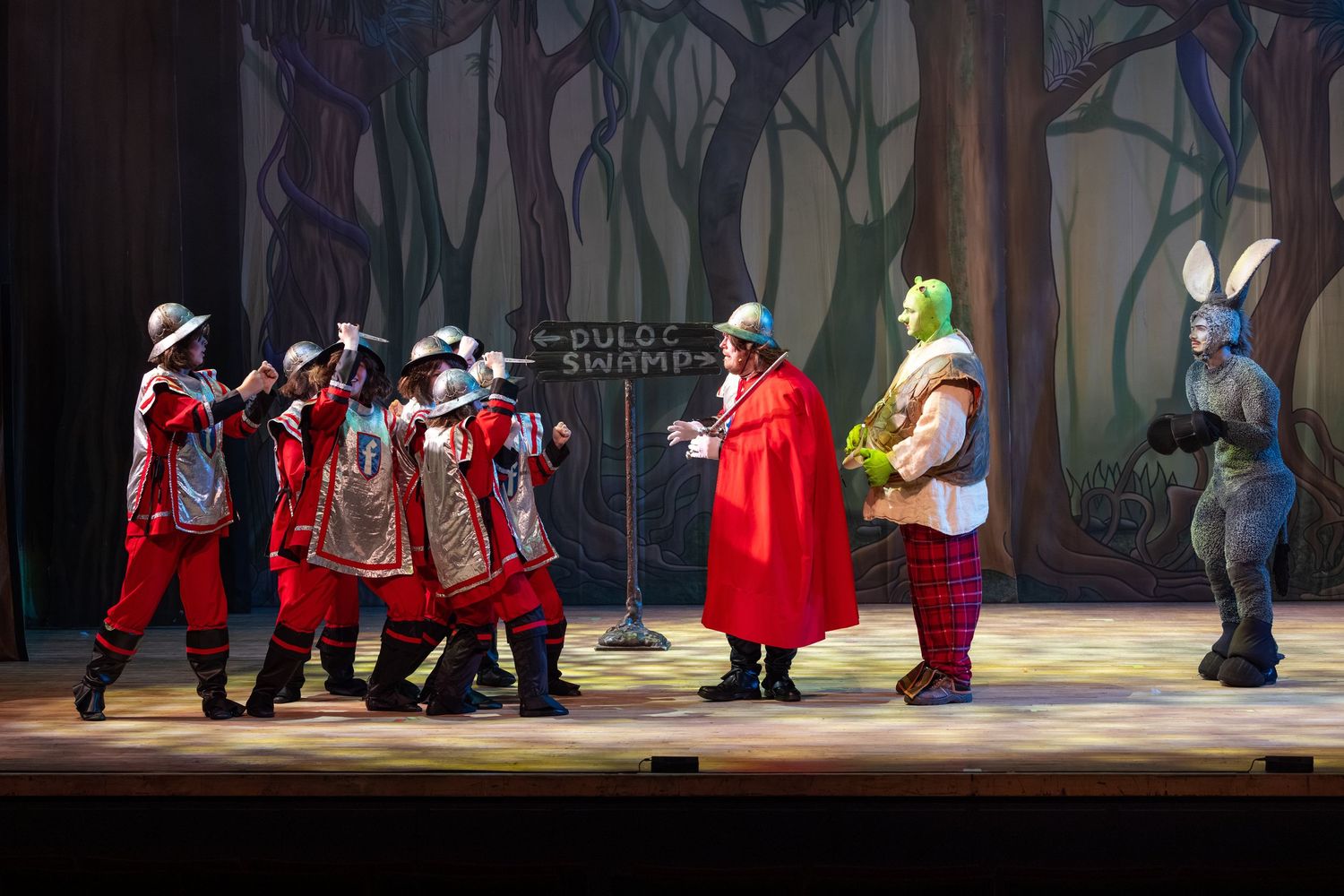 Shrek, Donkey and guards perform on a forest set in Shrek The Musical at Castle Theatre Wellingborough