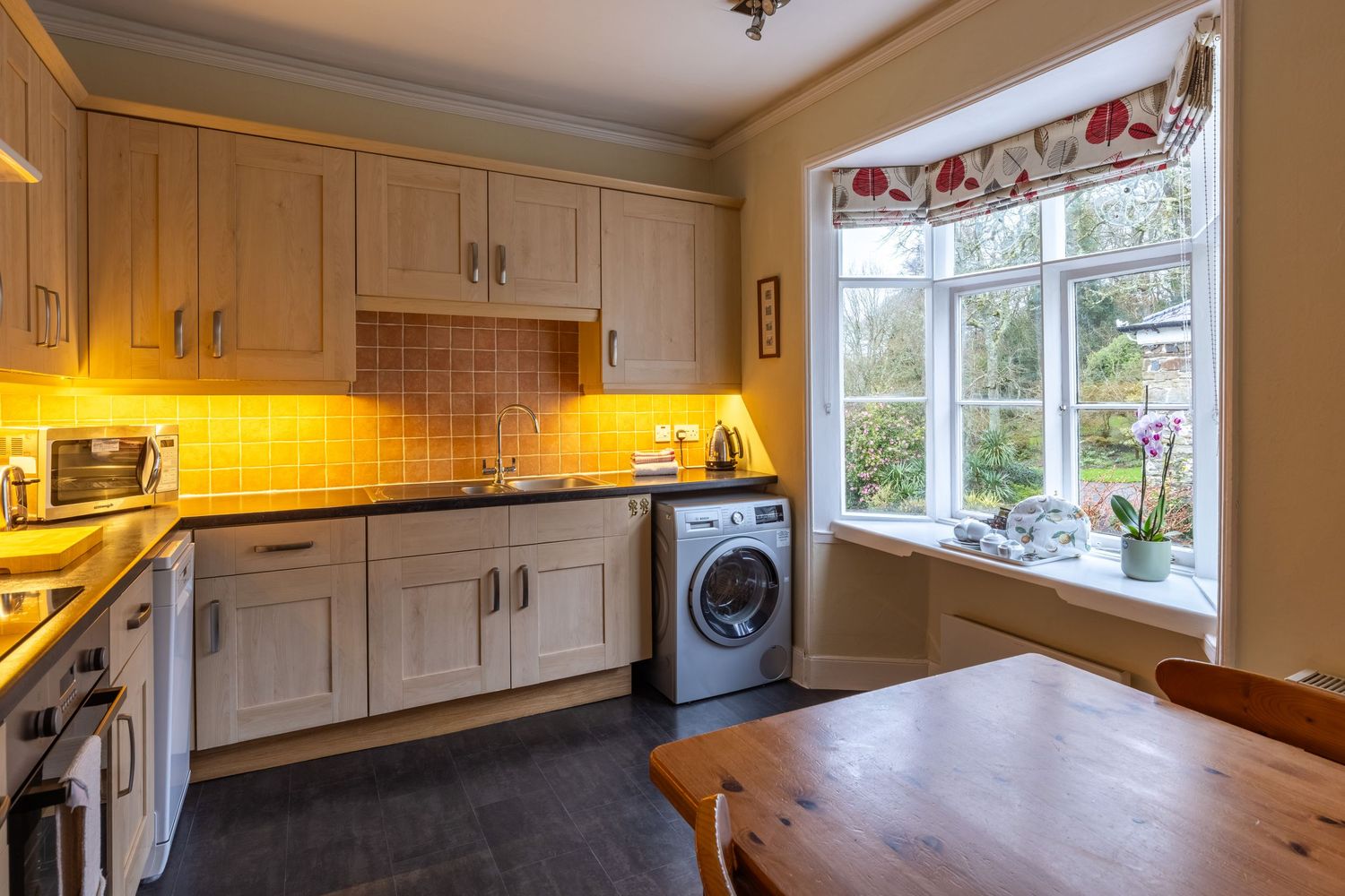 Bright kitchen with natural light, contemporary cabinetry and garden views photographed for property marketing.