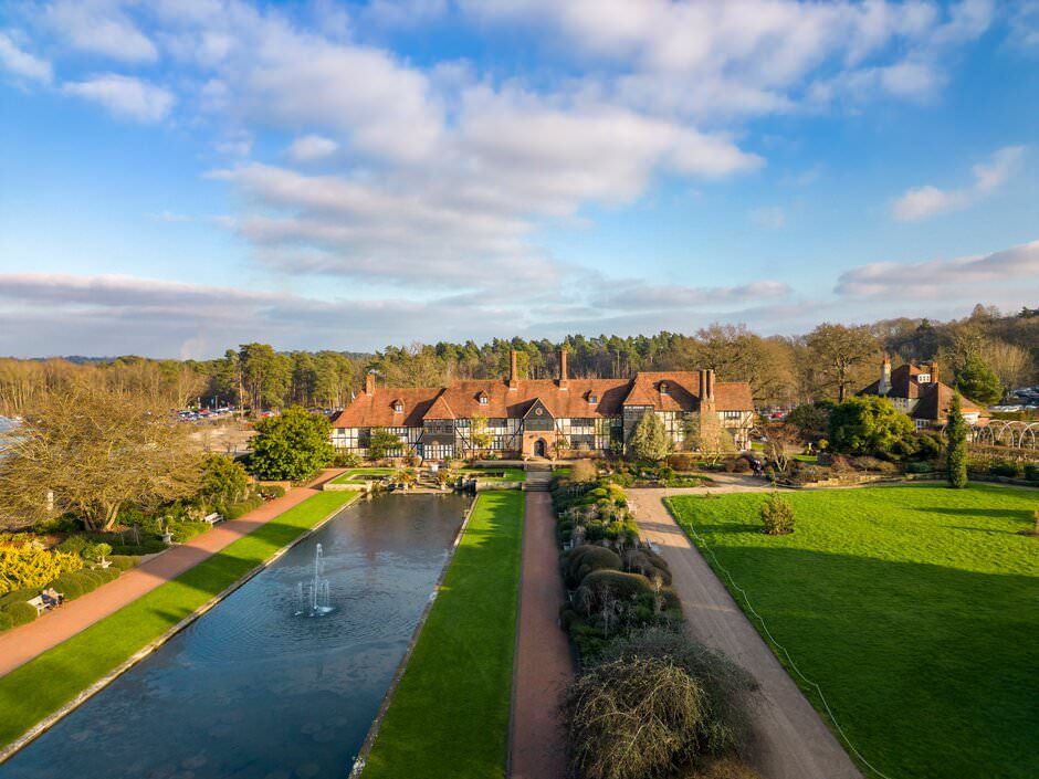Aerial view of a charming canal village with traditional brick houses and green gardens in rural England on a sunny day.