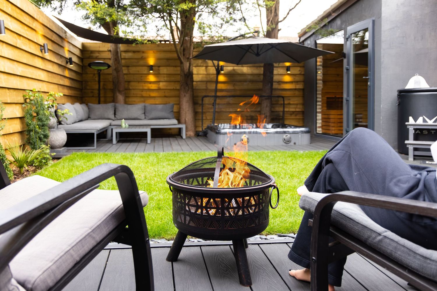 Garden spa patio in Bedfordshire with fire pit, seating and lawn, photographed for exterior photography shoot.