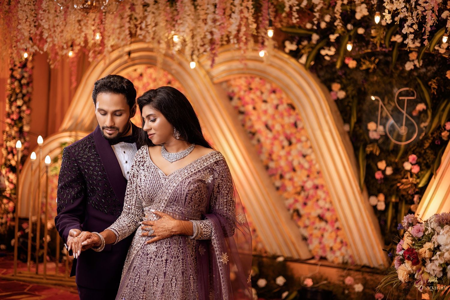 Bride and groom candid moment at wedding reception with floral arch decoration Chennai