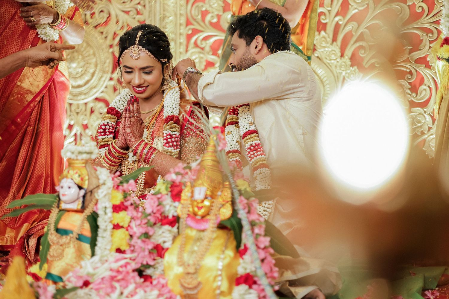 Groom performing wedding ritual for bride at traditional Tamil Hindu ceremony with floral decorations Chennai