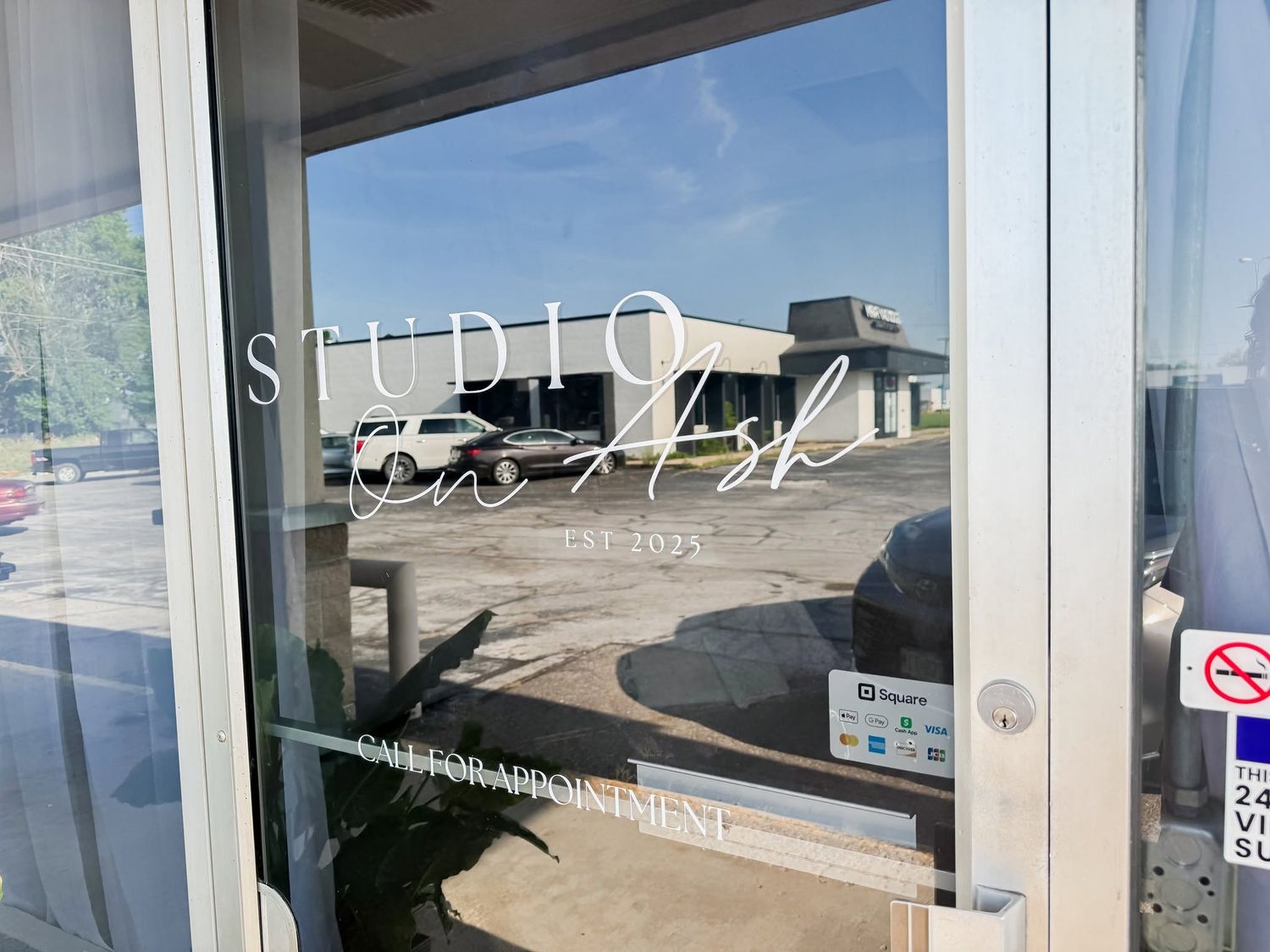 Studio Polish nail salon glass door entrance with elegant script logo, est. 2023, call for appointment sign.