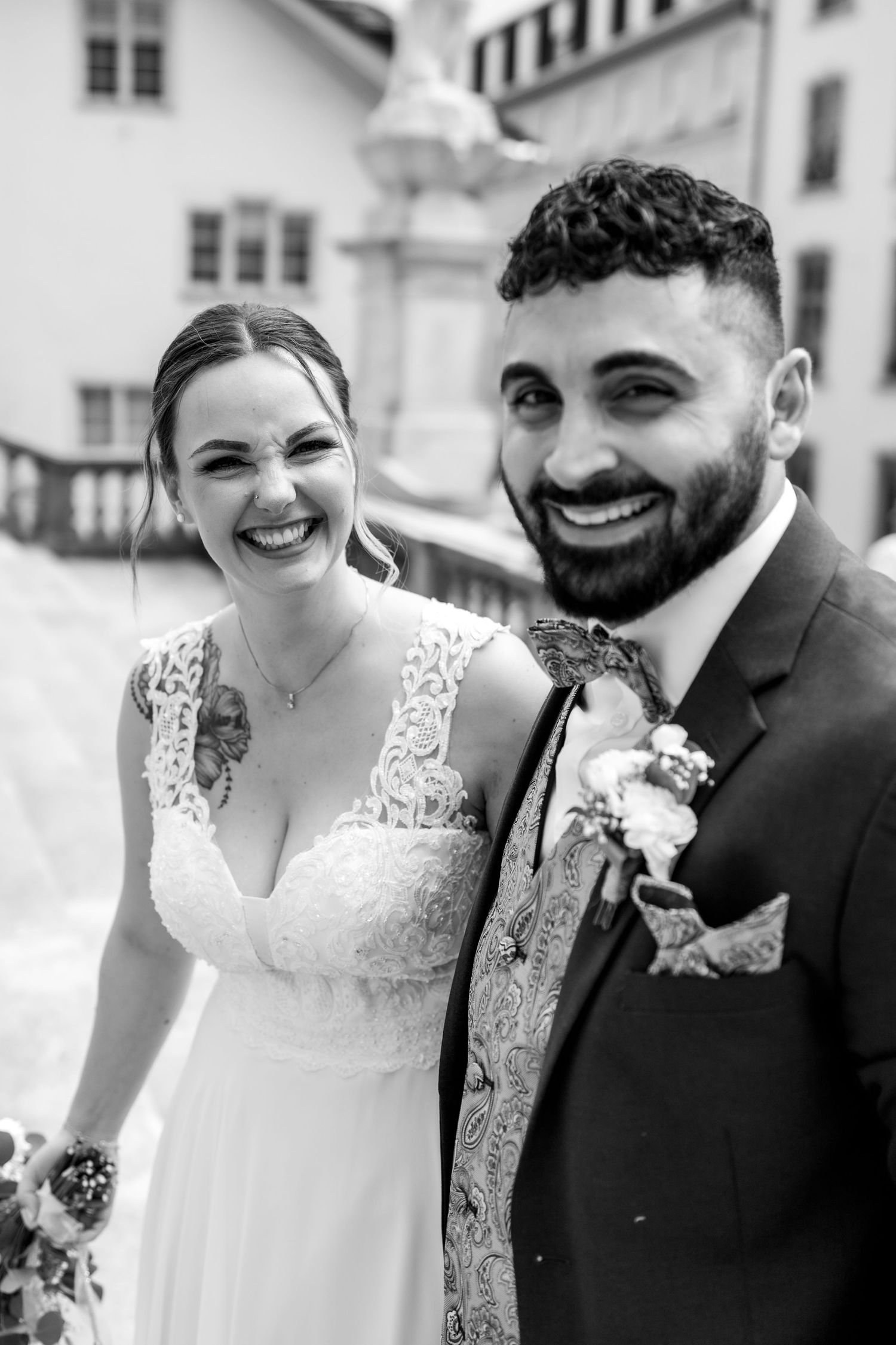 Strahlendes Brautpaar lacht glücklich in Schwarz-Weiss. Natürliche und ungestellte Hochzeitsfotografie Schweiz.