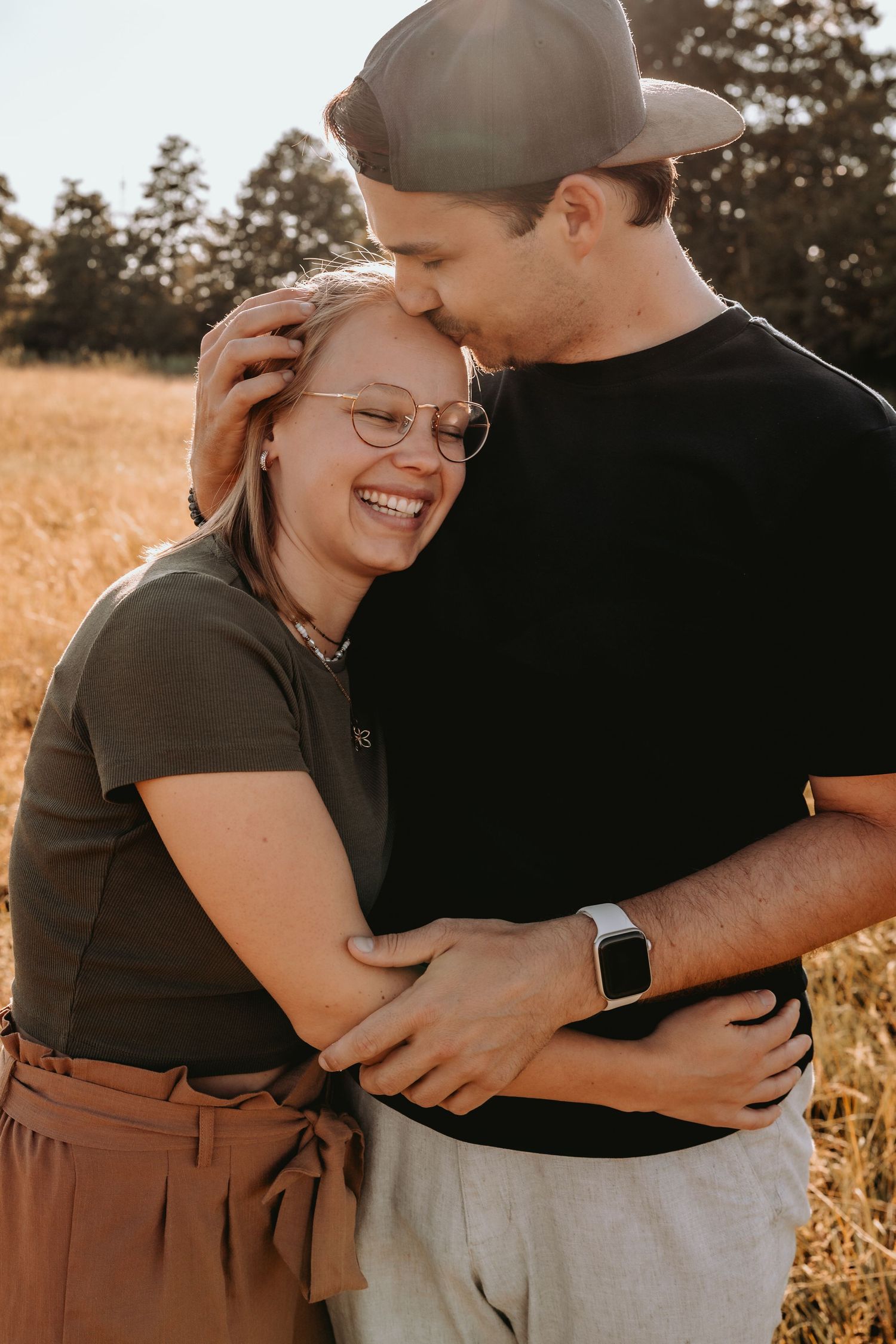 Paar lacht herzlich und umarmt sich entspannt in der Natur. Authentisches Kennenlernshooting für Hochzeiten in Solothurn.